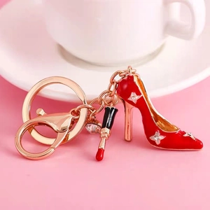 Detail of red stiletto and lipstick charms on a rose gold keychain for bags