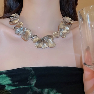 Macro shot of a silver layered leaf fringe necklace with a brushed metal texture finish