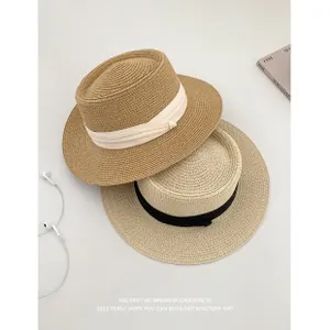 Detailed top view of two woven straw hats with khaki and beige ribbon accents