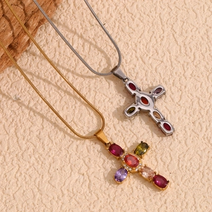 Detail of colorful gemstone cross pendant on 18K gold and silver snake chains