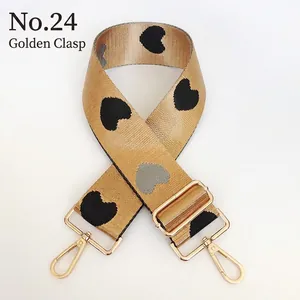 Detail view of adjustable wide nylon bag strap with heart patterns and gold lobster hooks