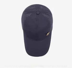 Close-up of navy baseball cap featuring breathable perforated fabric and gold metal badge