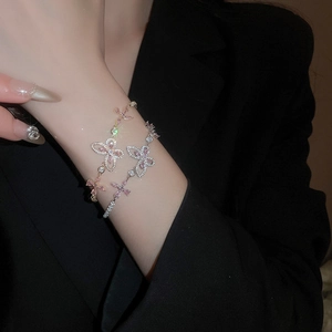 Macro detail of butterfly bracelets with pink zircon stones and rose gold plating