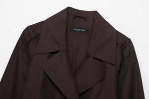 Detail of classic lapel and epaulets on a dark brown high-density twill cropped trench coat