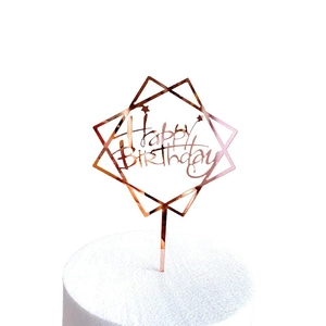 Rose gold acrylic Happy Birthday cake topper with geometric frame on white background
