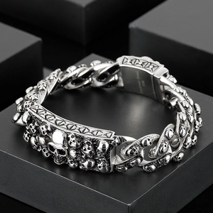 Detailed view of punk skull link bracelet on a black geometric stand with steel texture