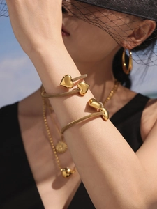 Close-up of golden mesh band heart bracelet with matching jewelry set on a model