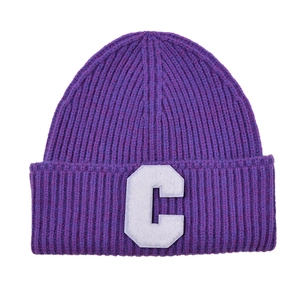Detailed close-up of purple ribbed knit beanie featuring a white letter C chenille patch