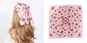 Detail of pink butterfly print satin square scarf shown worn as a headband and laid flat