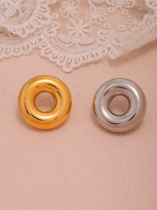 Close-up of gold and silver donut earrings with polished finish on lace background