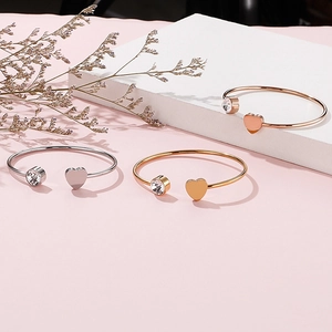 Vista dettagliata di bracciali a cuore in oro, argento e oro rosa con cristallo incastonato