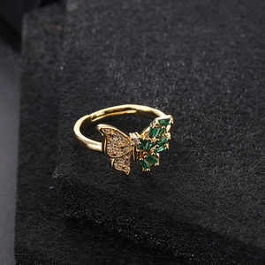 Detailed macro view of the gold butterfly ring with green zircon and white diamonds
