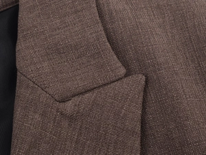 Gros plan détaillé sur la texture du tissu en tweed marron et le revers du blazer