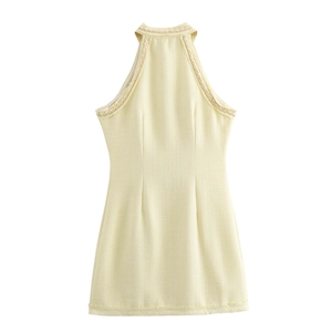 Texture détaillée de la robe dos nu en tweed jaune clair avec boutonnage simple