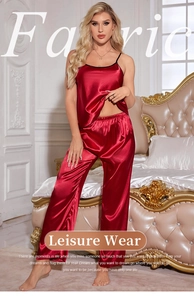 Detail of red satin pajamas with fine straps and black trim showing smooth silk texture