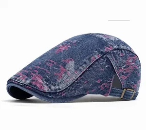 Dettaglio del berretto in denim blu scuro con stampa rosa e fibbia in metallo ottonato