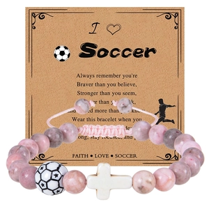 Soccer charm bracelet with pink spotted stone beads and a white cross on card