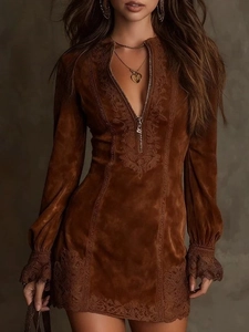 Close-up of brown suede dress with metal zipper and intricate lace trim details