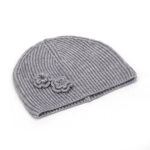 Detailed knit texture of a grey beanie featuring two handcrafted crochet floral accents