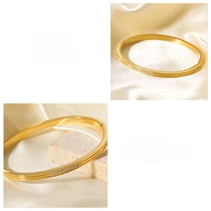 Detail view of 18k gold stainless steel bangle with inlaid zircons on white silk