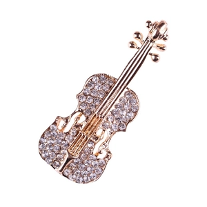 Elegante spilla a violino dorata con strass bianchi scintillanti su fondo bianco