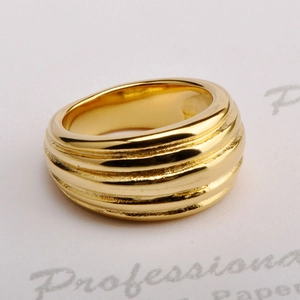 Macro shot of gold-plated titanium steel ring with wide layered horizontal texture