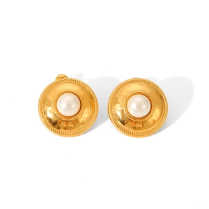 Close-up of vintage 18K gold plated earring with a white pearl inlay and hammered texture