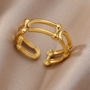 Detailed macro shot of adjustable hollow geometric gold-plated ring on satin