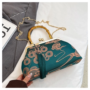 Detailansicht der dunkelgrünen Stickerei-Tasche mit Bambusgriff und Goldkettenriemen