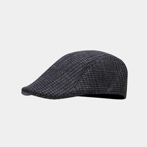 Close-up of charcoal grey plaid flat cap showing fine wool texture and classic pattern