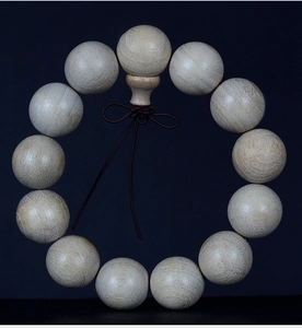 Macro detail of natural camphor wood prayer beads showing authentic grain and texture
