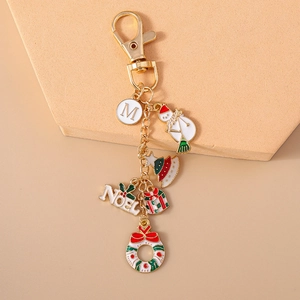 Detail of Christmas keychain with enamel charms: Santa, tree, gift box and Noel letters