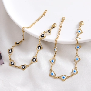 Adjustable stainless steel gold heart bracelet featuring blue and black evil eye charms