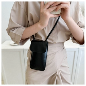 Close-up of a small black PU leather square crossbody bag worn by a model in beige outfit