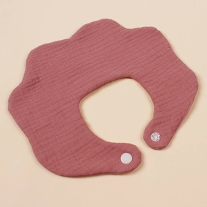 Detail van een baby slabbetje in de vorm van een bloemblad met drukknoopsluiting