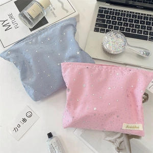 Detail of star-patterned makeup bags in pink and blue with elegant gold foil stars