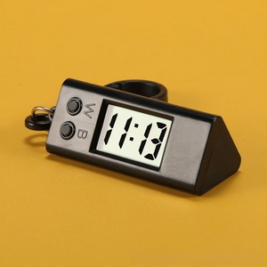 Macro detail of a black triangular portable electronic clock with clear LCD digital display