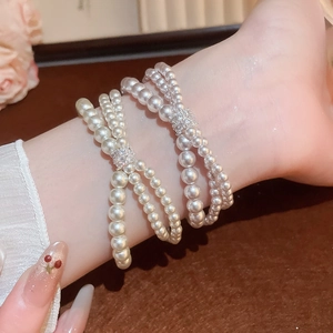 Close-up of triple-layer pearl bracelet with zircon buckle and elegant bead details