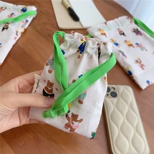 Detail of drawstring cotton pouch featuring cute bear prints and green cotton cords