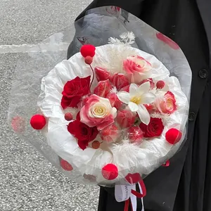Christmas strawberry and rose bouquet with white crepe paper and red pompoms wrapping