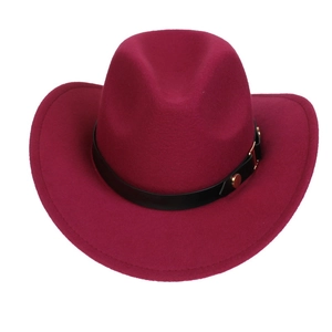 Detail of burgundy western cowboy hat with black leather band and gold metal rivets