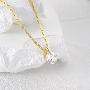 Detail of a gold plated S925 sterling silver necklace with a sparkling solitaire zircon