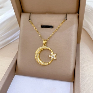 Détail du pendentif lune et étoile en acier titane avec zircons dans un écrin à bijoux