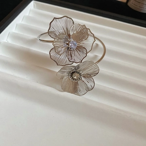 Detail of silver hollow flower cuff bracelet with sparkling crystals in a jewelry tray