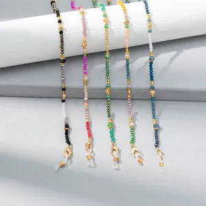 Macro view of colorful faceted crystal beaded eyewear chains with gold heart pendants