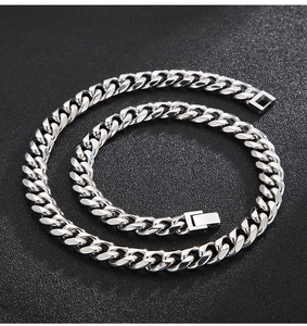 Detailed view of silver 10mm flat curb chain necklace with square buckle on dark background