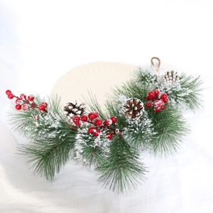 Macro detail of artificial pine needles with red berries and faux snow for Christmas decor