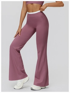 Détail du pantalon de yoga évasé à taille haute rose poudré avec liseré blanc