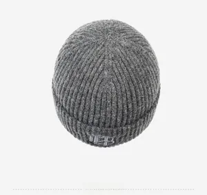 Détail de la bonnet tricoté gris foncé avec broderie HP sur le revers de la calotte