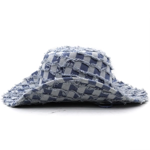 Detailansicht eines blau-weißen Fischerhuts aus Denim mit Fransen und Schachbrettmuster